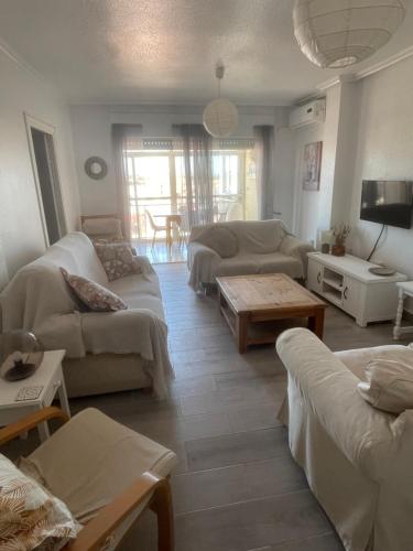 a living room with couches and a table at Lo Pagan Beachfront Aircon Apartment in San Pedro del Pinatar