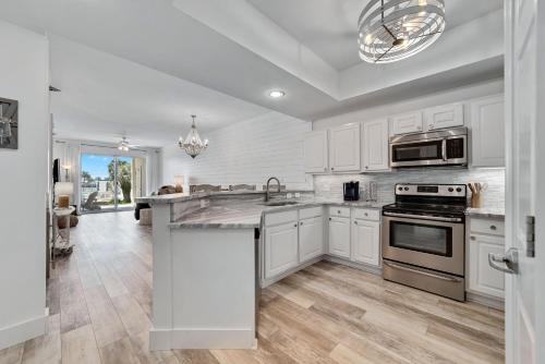 La cuisine est équipée de placards blancs et d'un four avec plaques de cuisson. dans l'établissement Harbor Cove Unit 111, à Orange Beach