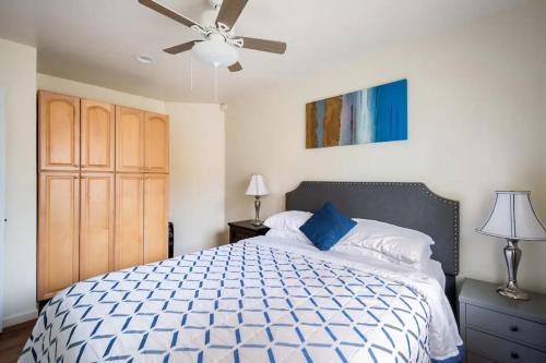 een slaapkamer met een bed en een plafondventilator bij Oasis with heated pool, mini golf, hot tub & barbq area in Oceanside