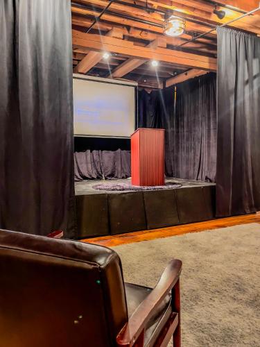 a stage with a screen and a chair in a room at Stylish Philly Loft in Philadelphia