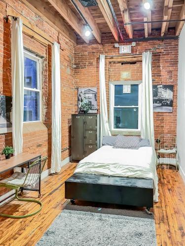 a bedroom with a bed and a brick wall at Stylish Philly Loft in Philadelphia