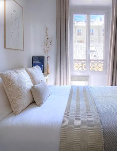 une chambre avec un lit blanc avec une fenêtre dans l'établissement Arty & Charming Le Marais, à Paris