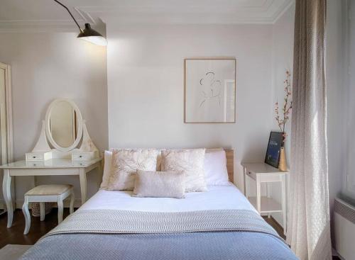une chambre blanche avec un lit et un miroir dans l'établissement Arty & Charming Le Marais, à Paris