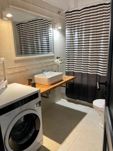 a washing machine in a bathroom with a sink at Casa Posidonia in Korinthos