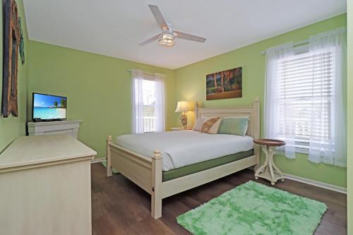 - une chambre avec des murs verts et un lit avec un ventilateur de plafond dans l'établissement Sweet Home Apalachee by Pristine Properties Vacation Rentals, à Indian Pass