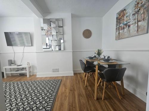a dining room with a table and chairs at St Albans City Stays - Near Luton Airport - St Albans Abbey & City Train station - Close to London- Harry Potter World - The Odyssey Cinema - Abbey Cathedral- Contractors I Business I Leisure- sleeps upto 6 people in St. Albans