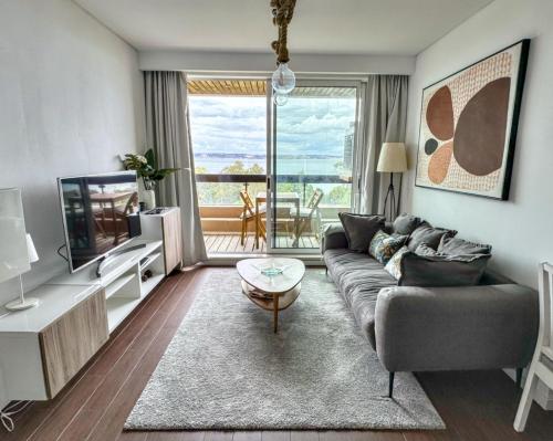 - un salon avec un canapé et une télévision dans l'établissement Alto da Barra *Ocean View, à Oeiras