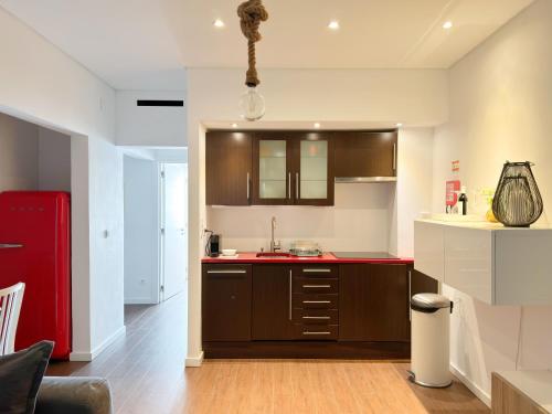 une cuisine avec des placards bruns et un comptoir rouge dans l'établissement Alto da Barra *Ocean View, à Oeiras