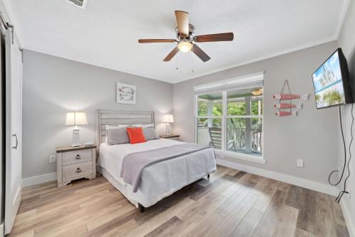 a bedroom with a bed and a ceiling fan at Bear Point Cottage in Orange Beach