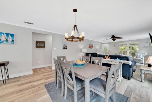a dining room and living room with a table and chairs at Bear Point Cottage in Orange Beach