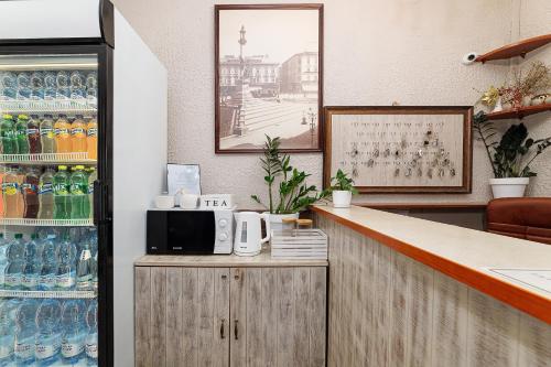 eine Küche mit einer Bar mit Mikrowelle und Sodaflaschen in der Unterkunft Готель Кайзер у Львові in Lwiw