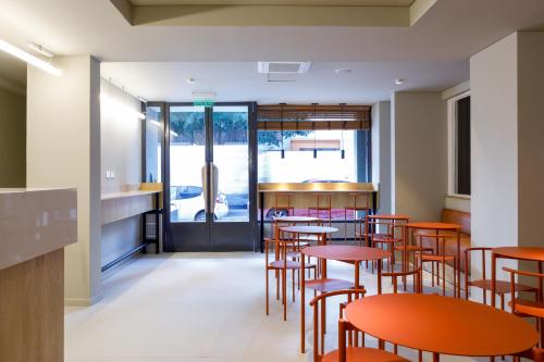 a dining room with orange tables and chairs at Bromelia Hotel Boutique in Buenos Aires