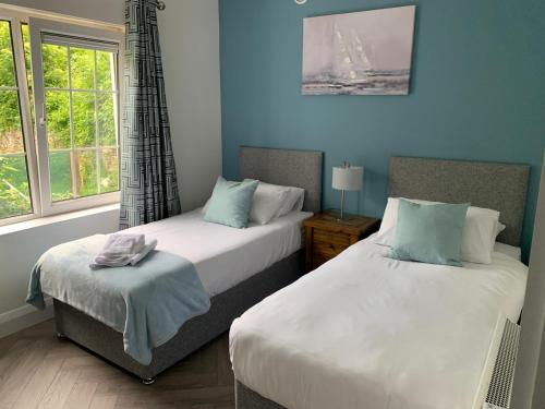 - une chambre avec 2 lits et une fenêtre dans l'établissement Town Center Beautiful 2 Bed Apartment, à Kinsale