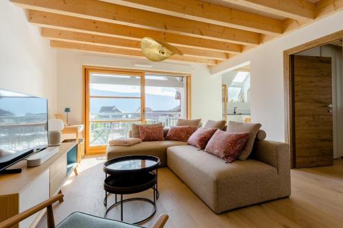 sala de estar con sofá y TV en Appartement Duplex vue lac et montagne à Talloires en Talloires