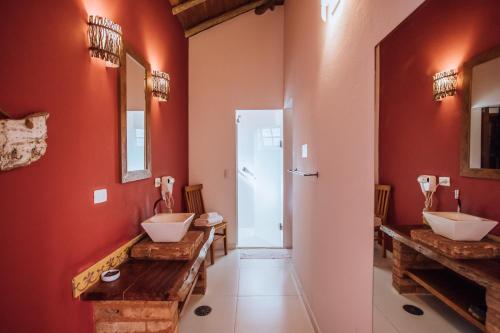a bathroom with two sinks and red walls at Pousada Terra Madre in Ilhabela
