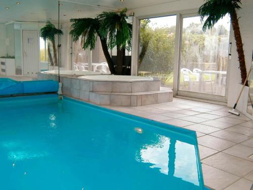 a blue swimming pool in a house with a patio at 8 person holiday home in Asperup in Asperup