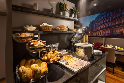 a buffet with bread and other food on a table at Midnight Hôtel Paris in Paris