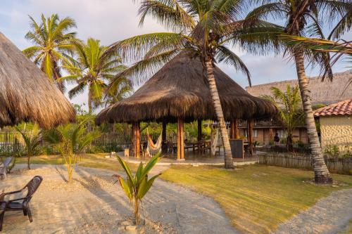 un complejo con una hamaca y dos palmeras en Paraíso Natural Ecohotel, en San Bernardo del Viento