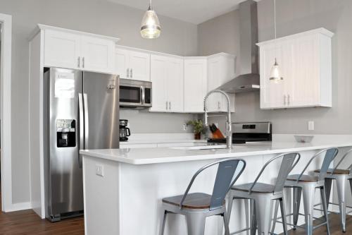 a kitchen with white cabinets and a counter with chairs at Gin Fizz by Pristine Properties Vacation Rentals in Port Saint Joe