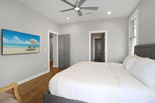 a bedroom with a white bed and a ceiling fan at Gin Fizz by Pristine Properties Vacation Rentals in Port Saint Joe