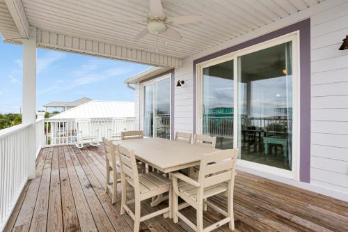 a porch with a table and chairs on it at Pearly Shells by Pristine Properties Vacation Rentals in Saint Joe Beach