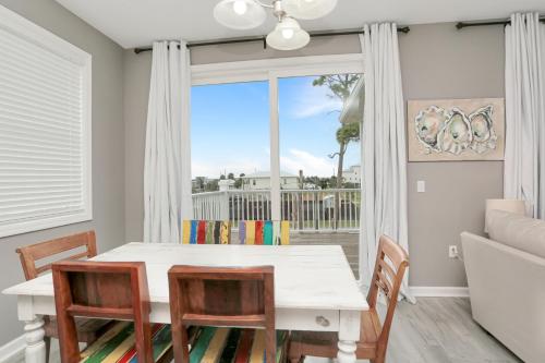 a dining room with a table and chairs and a large window at Pearly Shells by Pristine Properties Vacation Rentals in Saint Joe Beach