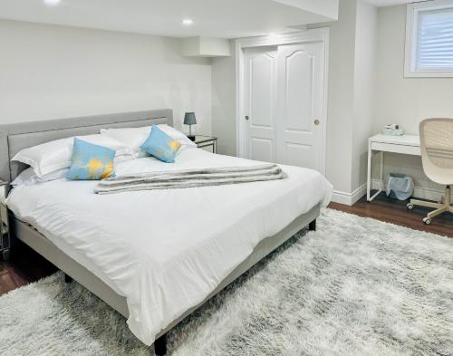 a bedroom with a large white bed with blue pillows at Spacious 2 Bedroom 1 bath Mississauga Basement Apartment in Mississauga