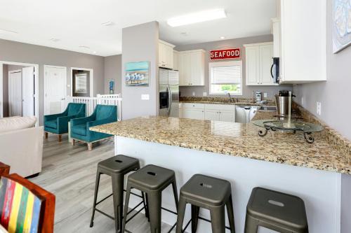 a kitchen and living room with a counter and stools at Pearly Shells by Pristine Properties Vacation Rentals in Saint Joe Beach