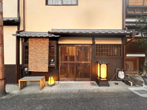 an entrance to a building with a bench and a lantern at Dormitory Omitsu in Nara