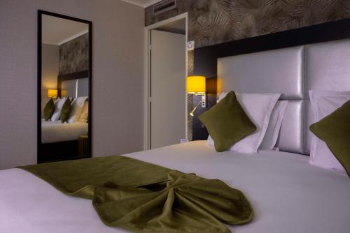 - une chambre avec un grand lit blanc et des oreillers verts dans l'établissement Best Western Allegro Nation, à Paris