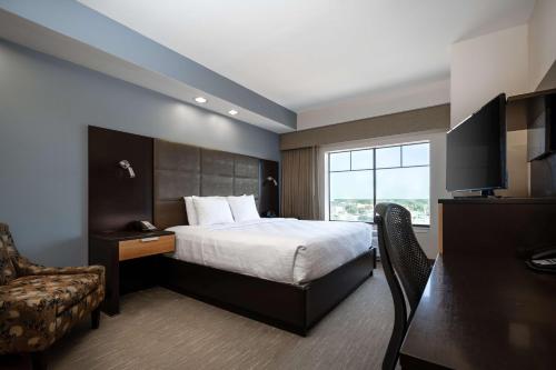 a hotel room with a bed and a window at Best Western Premier Bryan College Station in Bryan