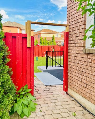 a red fence with a gate in a yard at Spacious 2 Bedroom 1 bath Mississauga Basement Apartment in Mississauga