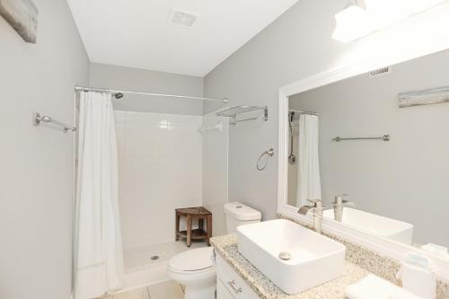 La salle de bains blanche est pourvue d'un lavabo et de toilettes. dans l'établissement Paradise By The Gulf by Pristine Properties Vacation Rentals, à Cape San Blas