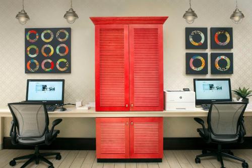 una oficina con puertas rojas y un escritorio con dos ordenadores en Home2 Suites by Hilton Hattiesburg, en Hattiesburg