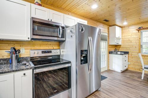 a kitchen with stainless steel appliances and wooden walls at Tennessee Mountain Cabin about 18 Mi to Knoxville! in Kodak