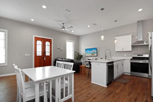 cocina con armarios blancos y mesa blanca en Sazerac by Pristine Properties Vacation Rentals, en Port Saint Joe