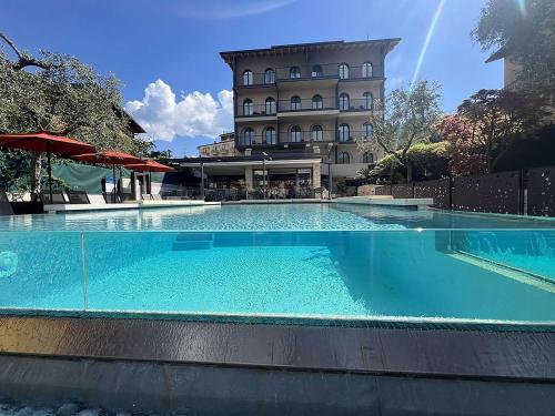 una grande piscina di fronte a un edificio di Hotel Al Caminetto WorldHotels Crafted Adults Only a Torri del Benaco