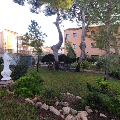 a park with trees and a statue in the grass at Albergue Rosa Molas in Arrabal de Jesús