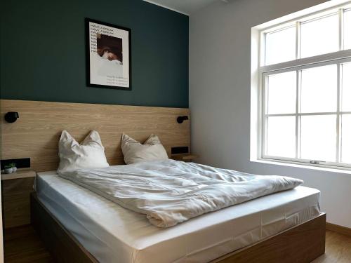 uma cama num quarto com uma parede verde em Aiden by Best Western Lolland em Holeby