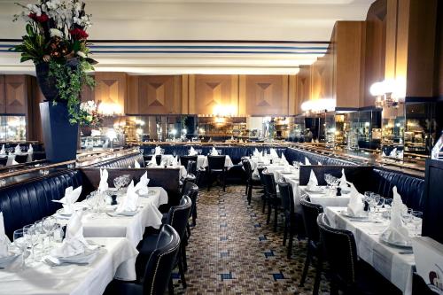 une salle à manger avec des tables et des chaises blanches dans l'établissement Studio Parisien individuel - GN, à Paris