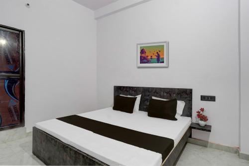 a bedroom with a large bed in a white room at OYO Flagship Hotel J. S in Kānpur