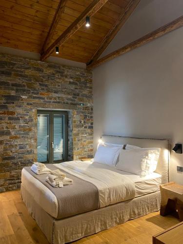 a bedroom with a large bed with a brick wall at EJ Boutique Suites in Milína