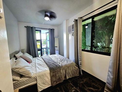 a bedroom with a bed and a window at Casas Bugambilias Upstairs Unit in Balamban