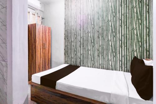 1 dormitorio con cama blanca y pared verde en OYO RELAXING PARADISE, en kolkata