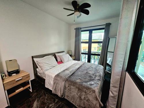 a bedroom with a bed and a ceiling fan at Casas Bugambilias Upstairs Unit in Balamban