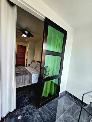 a bedroom with a bed and a glass door at Casas Bugambilias Upstairs Unit in Balamban