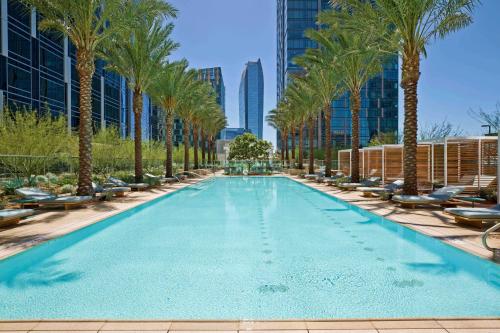a swimming pool with palm trees and buildings at Lavish High-Rise 2bed Apt in the Hearth of Downtown LA in Los Angeles