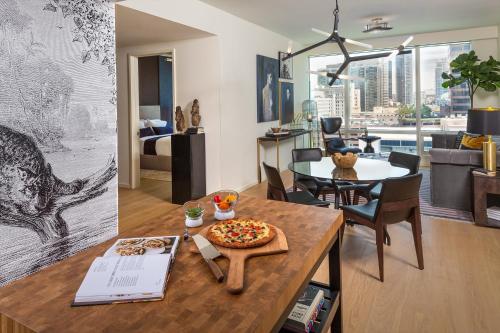 a living room with a table with a pizza on it at Lavish High-Rise 2bed Apt in the Hearth of Downtown LA in Los Angeles