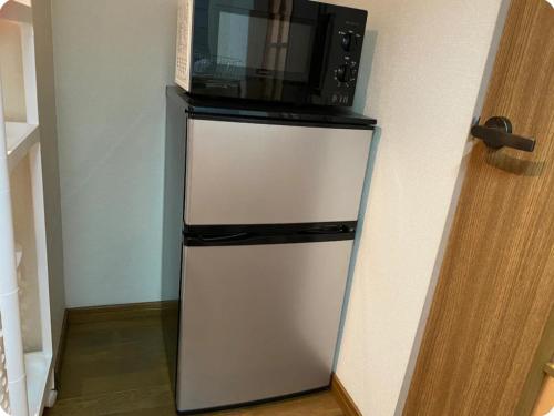 a microwave sitting on top of a white refrigerator at Rosemary 203 in Kagoshima