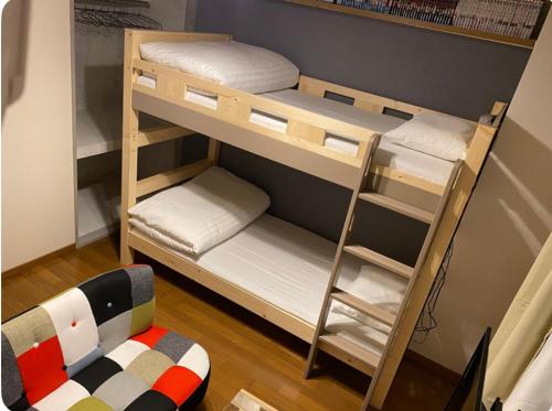 a room with two bunk beds and a chair at Rosemary 203 in Kagoshima